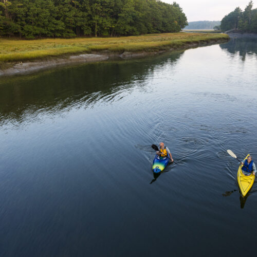 Two kayakers enjoy an early morning paddle on the York River in York, Maine.