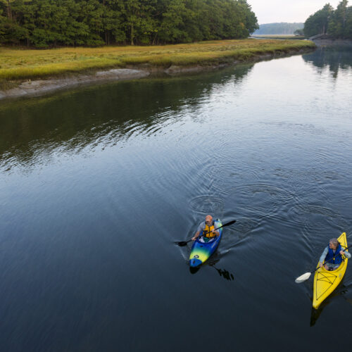 Two kayakers enjoy an early morning paddle on the York River in York, Maine.