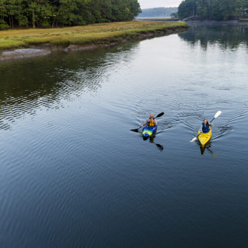 Two kayakers enjoy an early morning paddle on the York River in York, Maine.