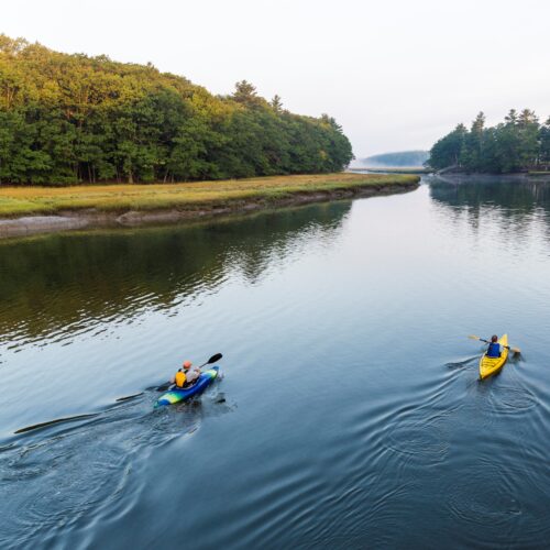 Two kayakers enjoy an early morning paddle on the York River in York, Maine.